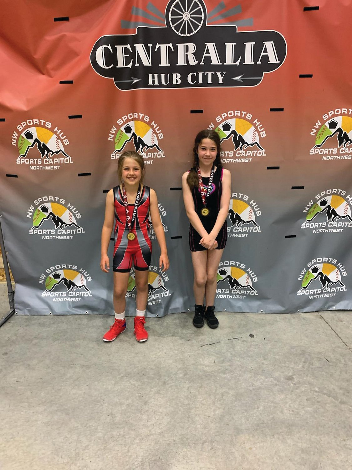 Savannah Grimm, 11, and sister Layla Grimm, 9, pose for a photo after winning medals at the Washington State Wrestling Association’s Super State Championship.